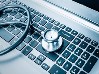 Computer system health or auditing - Stethoscope over a computer keyboard toned in blue